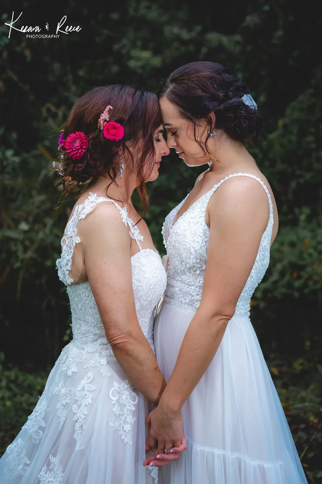 Two brides touching foreheads on their wedding day